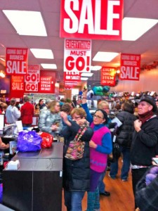 Women at store counter under closing sale signs Retail Store Closing